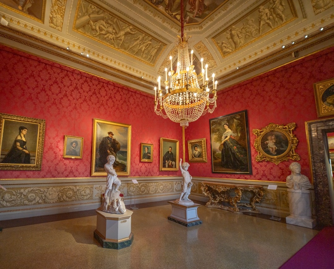 Ornate room with paintings, sculptures, and crystal chandelier.